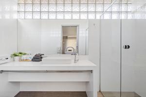 a white bathroom with a sink and a mirror at Pet Room at Moody's in Blairgowrie