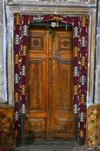 a wooden door with curtains on top of it at Grand Nodirbek Boutique Hotel in Bukhara