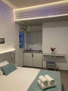 a bedroom with a bed with towels on it at Armeno Studios in Limenaria