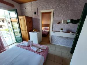 sypialnia z dużym łóżkiem i lustrem w obiekcie Sun Helios Garden Aparthotel w mieście Limenas