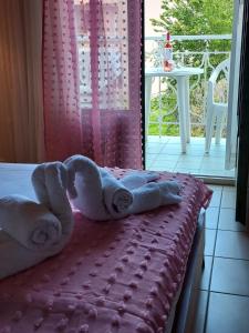 a towel animal laying on a bed in a room at Sun Helios Garden Aparthotel in Limenas