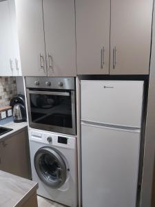 a kitchen with a washing machine and a refrigerator at Nantias Luxury Home in Alexandroupoli