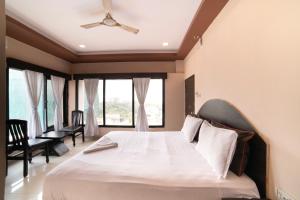 a bedroom with a large bed with a ceiling fan at Hotel Searock in Visakhapatnam
