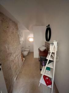 een badkamer met een stenen muur, een toilet en een ladder bij Trullo Al Guappo d'Oro in Ostuni