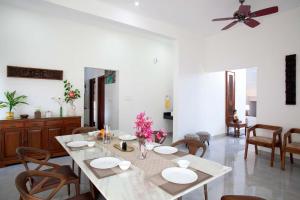a dining room with a table and chairs and a ceiling fan at StayVista at Ivory Hill Madikeri including breakfast 3 Bhk Villa in Madikeri