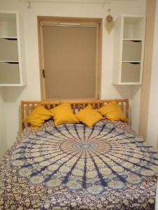 a bedroom with a bed with yellow pillows at Mieszkanie z hamakiem in Gdańsk