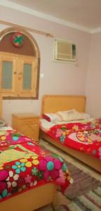 sypialnia z 2 łóżkami i lustrem w obiekcie بيت سيدون السياحي w mieście Aswan