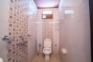 a small bathroom with a toilet and a shower at Hotel Searock in Visakhapatnam