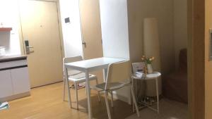 a kitchen with a white table and two stools at Cozy Home 1 bedroom in Manila