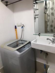 a bathroom with a sink and a toilet and a mirror at Cozy Home 1 bedroom in Manila