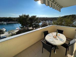 a balcony with a table and chairs and a view of the water at Beachfront Lovro apartment in Šimuni