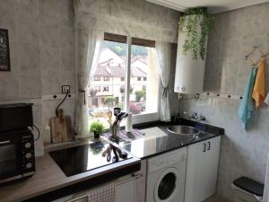 a kitchen with a sink and a washing machine at Mirador del Oja in Ezcaray +17 photos