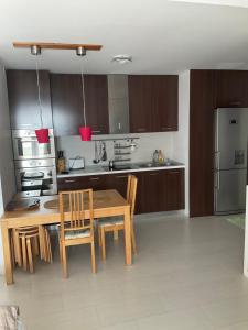 a kitchen with a table and chairs and a refrigerator at Vila Jolie in Costinesti