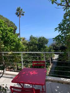 a red chair sitting on a porch with a view of the ocean at Casa di Mare in San-Martino-di-Lota