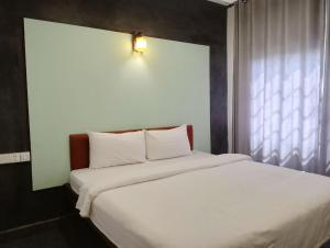 een slaapkamer met een wit bed en een raam bij Shalima Guesthouse in Siem Reap