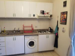 a kitchen with a washing machine and a sink at Berdawny Apartments in Zahlé