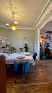 a dining room with a white table and blue chairs at luxury Villa Marie Emeraude Paris Orly Jacuzzi in Draveil
