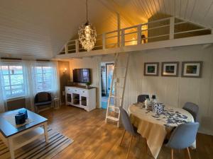 Lofotbua في Offersøya: غرفة معيشة مع طاولة وسرير علوي