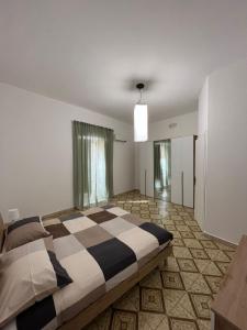 - une chambre avec un grand lit et un sol en damier dans l'établissement Casa di Giovi, à Caltagirone