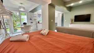 een slaapkamer met een oranje bed met handdoeken erop bij L'Indépendant in Nemours