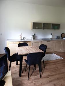 uma cozinha com uma mesa de madeira e cadeiras num quarto em Apartament Żeglarski Vęgoria em Węgorzewo