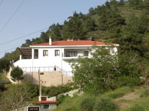 una casa bianca sul fianco di una collina di Ta Spitakia tis Theodosias a Kalopanayiotis