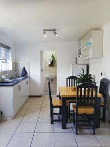 une cuisine et une salle à manger avec une table et des chaises dans l'établissement Rondebosch East Garlandale STRICTLY HALAAL, fresh garden cottage, au Cap