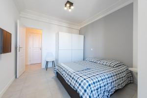 a white bedroom with a bed and a white cabinet at VILLA VELLEDA in Juan-les-Pins