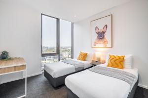 墨尔本Mega Style Apartments Epic的有窗户的房间里有两张床