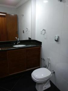 a bathroom with a toilet and a sink at Pousada Casa do Jova em Raposo RJ 