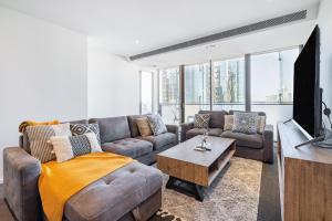 墨尔本Mega Style Apartments Epic的客厅里有一张沙发和一台电视