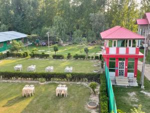 hotel new sahil في سريناغار: اطلالة جوية على حديقة بها طاولات وكراسي بيضاء