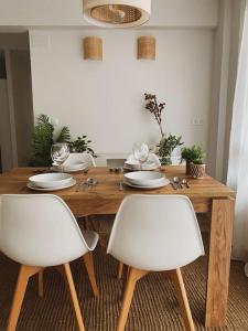 uma mesa de madeira com duas cadeiras brancas à volta em Apartment in Sopelana em Sopelana