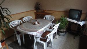 une table à manger avec des chaises blanches et une télévision dans l'établissement Ranch Eden, Jeseník, à Jeseník
