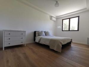 een slaapkamer met een bed, een dressoir en een raam bij Bas de Villa au Calme in Villeneuve-Loubet