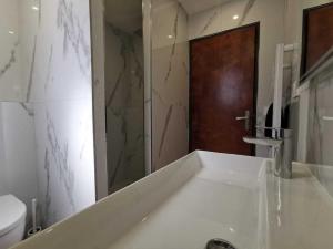 ヴィルヌーヴ・ルベにあるBas de Villa au Calmeの白いバスルーム(洗面台、トイレ付)
