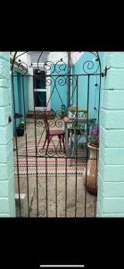 una puerta de hierro forjado con un banco y una mesa en The Shell House en Falmouth
