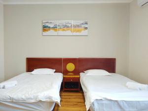 two beds in a room with white sheets at Milky Way Hotel in Budapest