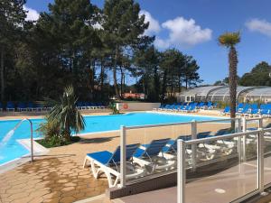 uma piscina com espreguiçadeiras e um resort em Camping du Bois Dormant em Saint-Jean-de-Monts