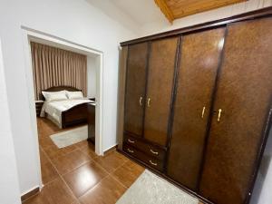 1 dormitorio con 1 cama y un gran armario de madera en Al-Daar, en ‘Ayn Amūn