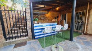 a patio with a blue bench and two chairs at For U 2 Stay in Pretoria