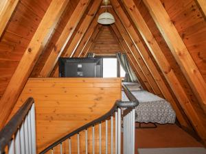 a staircase in a log cabin with a television in it at 171 Snowdonia View in Pwllheli