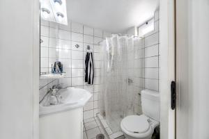 Baño blanco con aseo y lavamanos en Calma Home, en Prasás