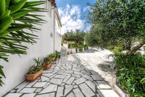 a stone walkway with potted plants on the side of a building at Calma Home in Prasás