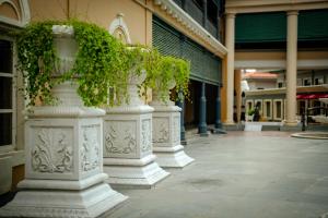 a row of pillars with plants on them in a building at Raajkutir - IHCL SeleQtions in Kolkata