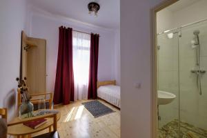 a bathroom with a shower and a bedroom with a bed at Elimheim in Cisnadioara