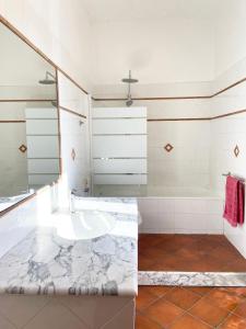 ein Badezimmer mit einer Badewanne und einem Waschbecken in der Unterkunft Podere San Giovanni in Pomaia