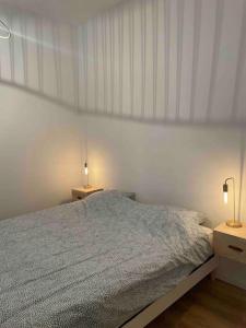 ein weißes Schlafzimmer mit einem Bett und zwei Nachttischen in der Unterkunft Bel appartement au cœur de Marseille in Marseille
