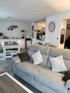 salon z szarą kanapą i kuchnią w obiekcie Villa avec jardin et piscine w mieście Cras