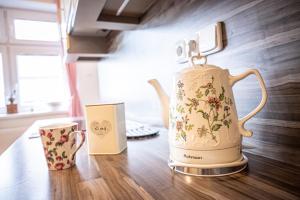 a tea kettle and a cup on a table at Vila Lumír in Poděbrady